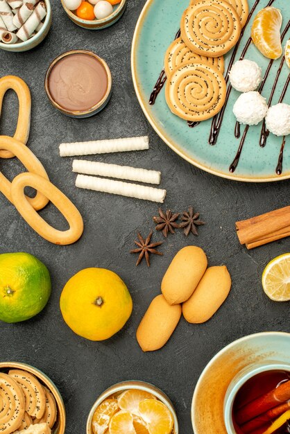 Bovenaanzicht kopje thee met fruit en koekjes op de donkere achtergrond