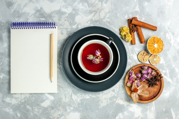 Bovenaanzicht kopje thee met kaneel en blocnote op witte muur thee zoete drank bloem