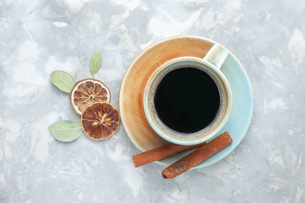 Bovenaanzicht kopje thee met kaneel op het witte oppervlak drinken thee kaneel citroen kleur