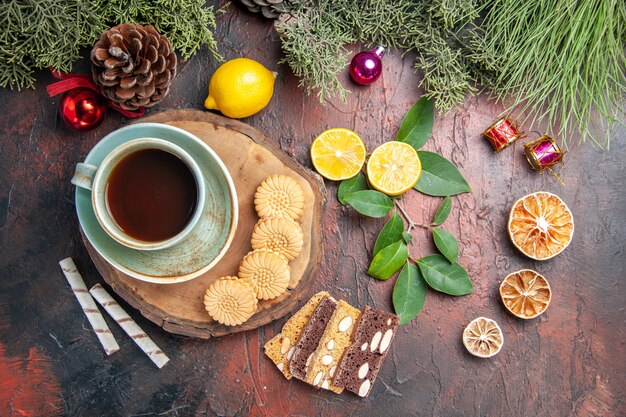 Bovenaanzicht kopje thee met koekjes en cake op een donkere tafel zoete taart cake koekjes