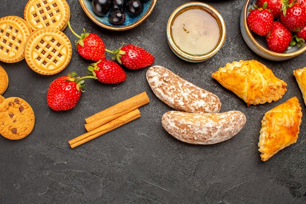 Bovenaanzicht kopje thee met koekjes en fruit op donkere vloer zoete koekje fruitcake