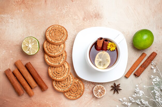 Bovenaanzicht kopje thee met koekjes en kaneel op witte tafel citroenthee koekje