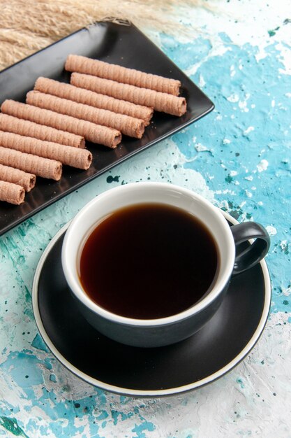 Bovenaanzicht kopje thee met koekjes op lichtblauw oppervlak