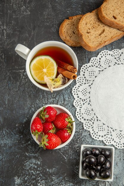 Bovenaanzicht kopje thee met olijven en fruit op donkere ondergrond 's ochtends eten ontbijt