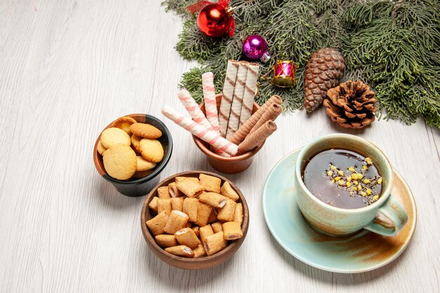 Bovenaanzicht kopje thee met verschillende koekjes op witruimte