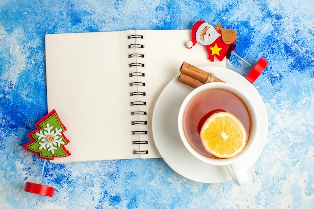 Bovenaanzicht kopje thee xmas ornamenten notebook op blauwe tafel