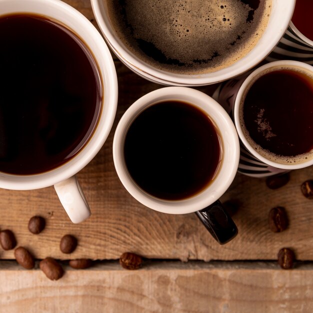 Bovenaanzicht kopjes koffie met houten achtergrond