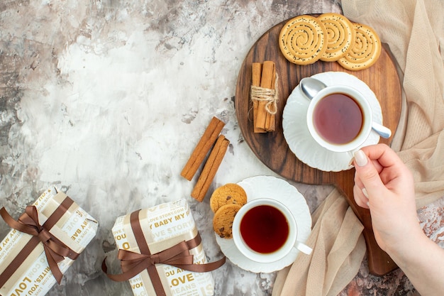 Bovenaanzicht kopjes thee met zoete koekjes en cadeautjes op lichte achtergrondkleur ceremonie pauze taart taart koffie suiker