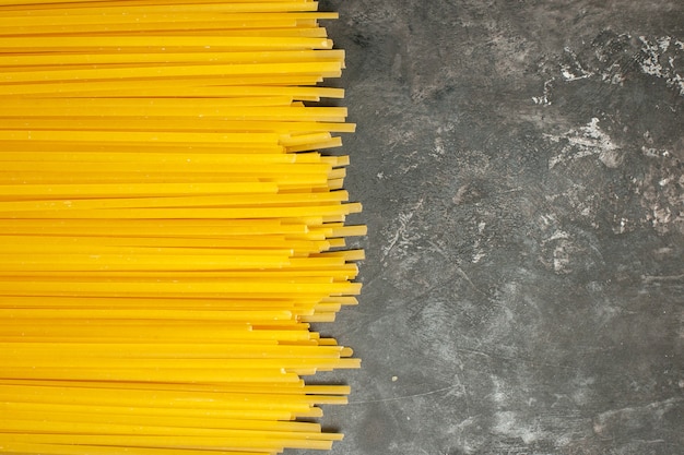 Bovenaanzicht lange italiaanse pasta op lichtgrijze achtergrond