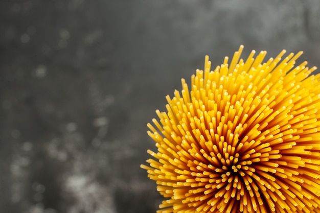 Bovenaanzicht lange Italiaanse pasta rauw op de donkergrijze achtergrond