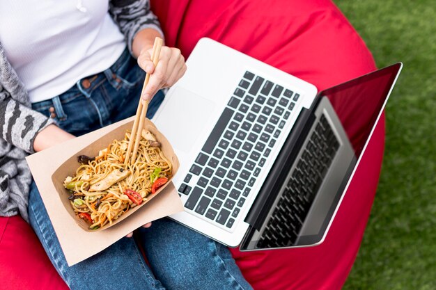 Bovenaanzicht laptop en fast food in het park