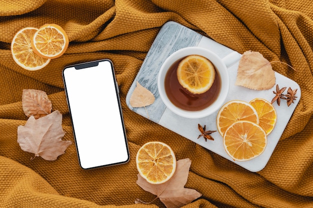 Gratis foto bovenaanzicht lege telefoon met thee en gedroogde schijfjes citroen