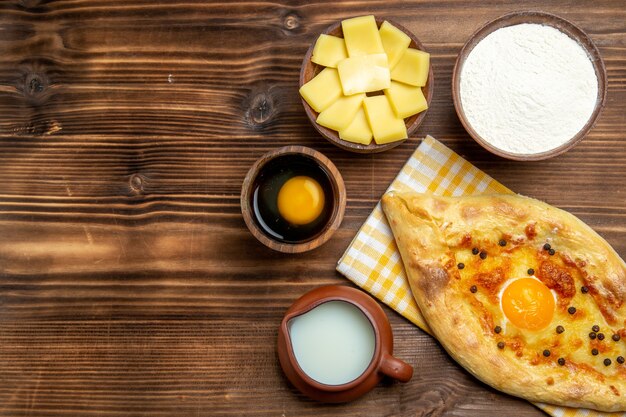 Bovenaanzicht lekker eierbrood vers uit de oven met melk op houten bureau deeg bakken brood broodje ei