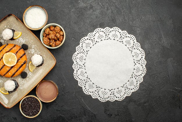 Bovenaanzicht lekker klein taartje met kokossnoepjes op donkergrijs oppervlak cake thee biscuit koekje zoet