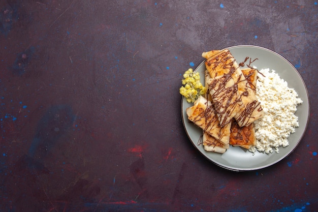 Bovenaanzicht lekker zoet gebak met kwark op de donkere achtergrond koekjes koekje suiker zoete cake thee