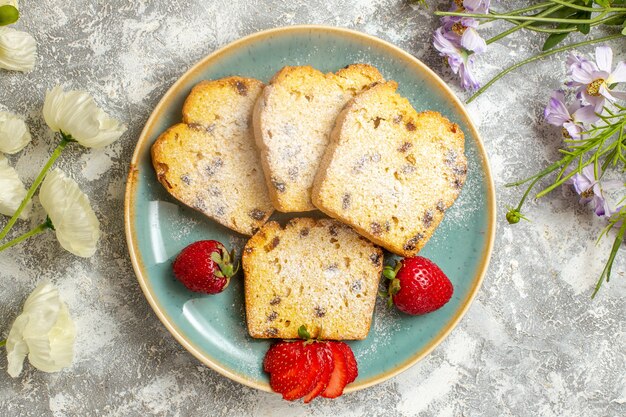 Bovenaanzicht lekkere cake plakjes met aardbeien op licht