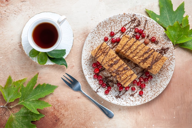 Bovenaanzicht lekkere cakeplak met thee en bessen op licht