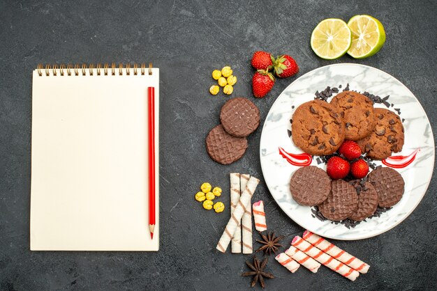 Bovenaanzicht lekkere choco koekjes voor thee op donkere bureauthee zoete koekjessuiker