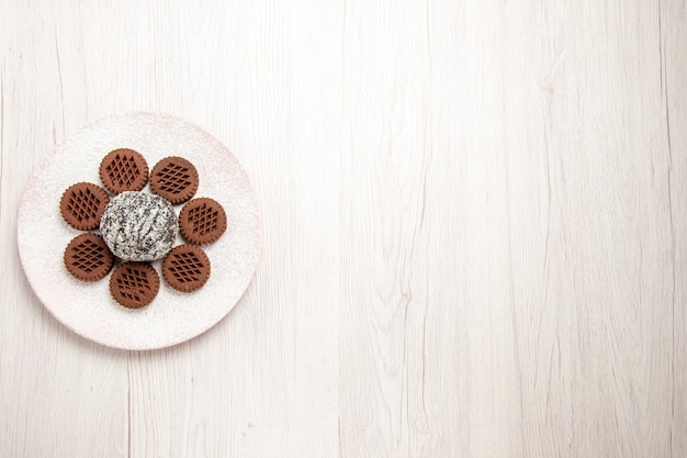 Bovenaanzicht lekkere chocoladekoekjes met kleine cacaocake op wit