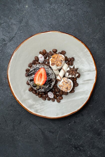 Bovenaanzicht lekkere chocoladetaart met chocoladeschilfers op het grijze oppervlak