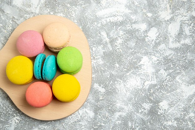 Bovenaanzicht lekkere Franse macarons kleurrijke taarten op het witte bureau