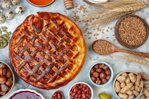 Bovenaanzicht lekkere fruitige taart met noten en eieren op licht bakken biscuit taart dessert cake cookie bakkerij broodje kleur