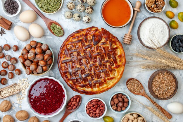 Bovenaanzicht lekkere fruitige taart met noten en eieren op licht bakken biscuit taart dessert thee cake cookie bakkerij broodje