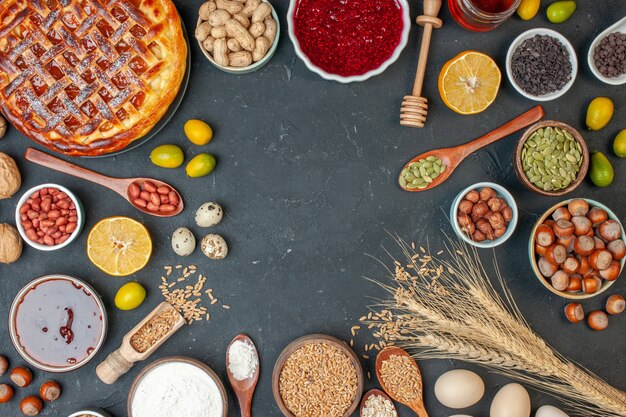 Bovenaanzicht lekkere fruittaart met eieren en noten op donkere kleur deegnoot fotocake rozijnenkoekjestaartdessert