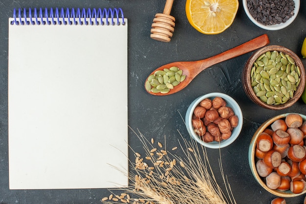 Bovenaanzicht lekkere fruittaart met notitieblok en noten op donkere kleur voedseldeeg noten foto cake