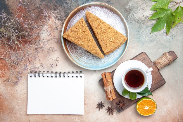 Bovenaanzicht lekkere honingcake met kopje thee op licht