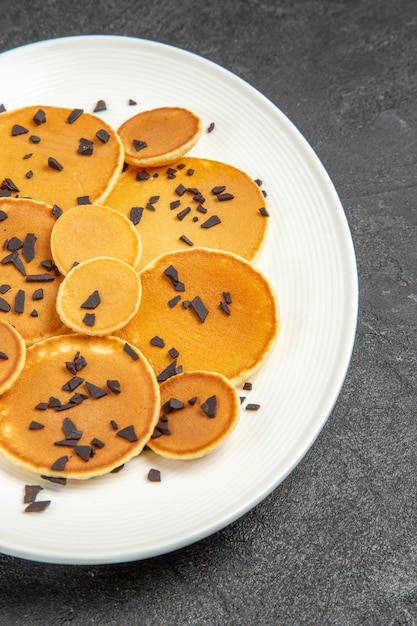 Gratis foto bovenaanzicht lekkere pannenkoeken met choco chips op de donkere achtergrond