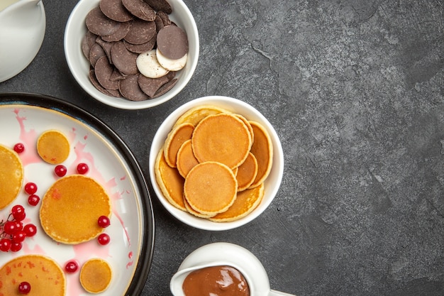 Bovenaanzicht lekkere pannenkoeken met koekjes op de grijze achtergrond