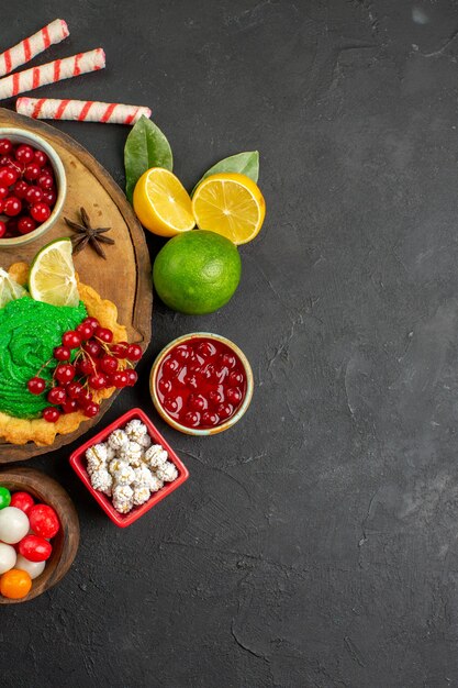 Bovenaanzicht lekkere romige cake met fruit op donkere achtergrond zoete koekjes cookie