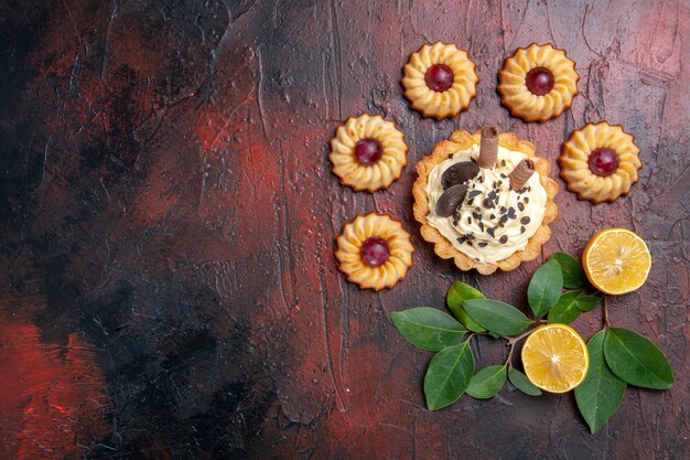 Bovenaanzicht lekkere romige cake met koekjes op de donkere tafel dessert zoete koektaart