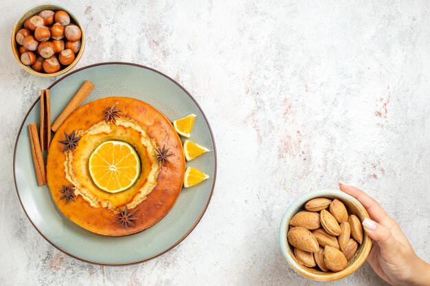 Bovenaanzicht lekkere taart heerlijk dessert voor thee met stukjes sinaasappel op witte achtergrond fruitcake taart theekoekje zoet dessert