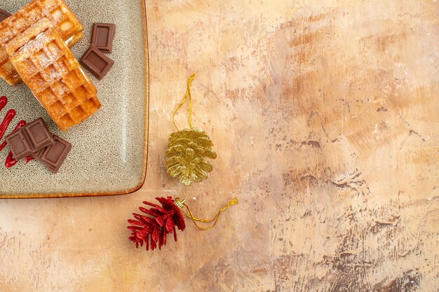 Bovenaanzicht lekkere wafelkoekjes met chocoladerepen op de bruine achtergrond