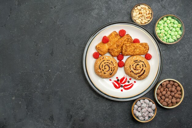 Bovenaanzicht lekkere zoete koekjes binnen plaat op grijze achtergrond biscuit zoete suiker cake koekjes thee