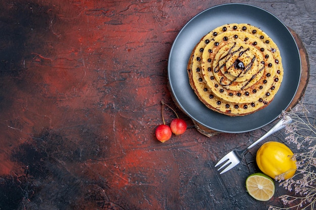 Bovenaanzicht lekkere zoete pannenkoeken met choco glazuur op donkere ondergrond