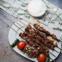 Gratis foto bovenaanzicht lule kebab met tomaat en ui en ayran