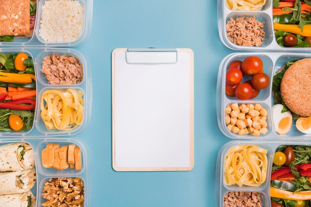 Bovenaanzicht lunchboxen met lege notebook