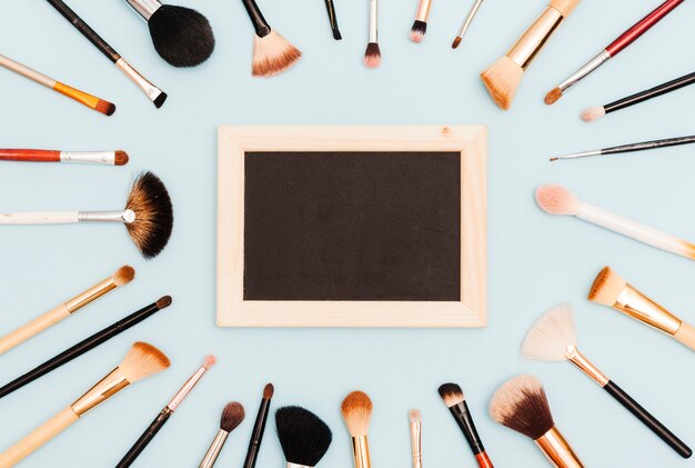 Bovenaanzicht make-up borstels met schoolbord