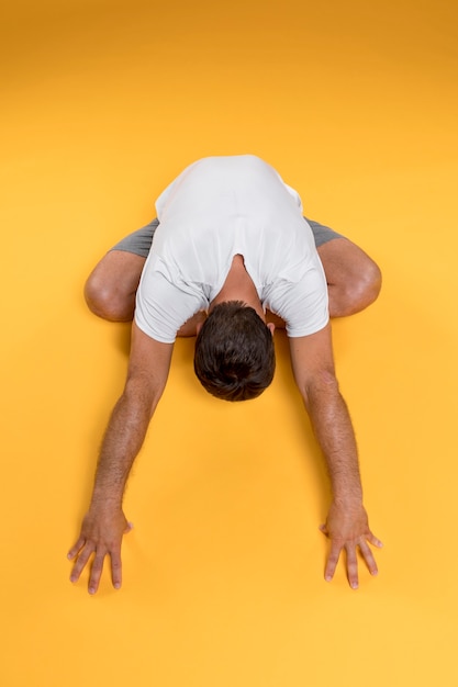 Gratis foto bovenaanzicht man die zich uitstrekt in yoga pose