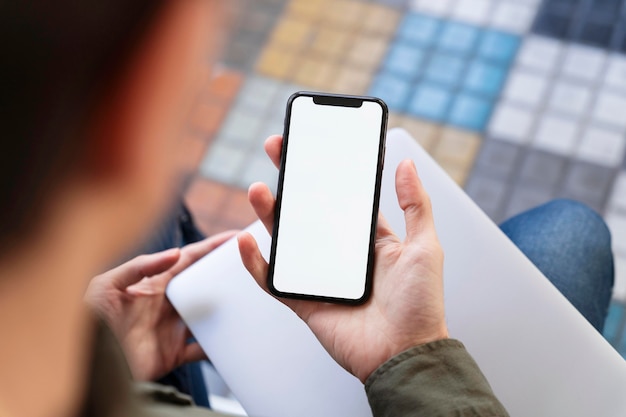 Bovenaanzicht man kijkt naar zijn telefoon met een leeg scherm