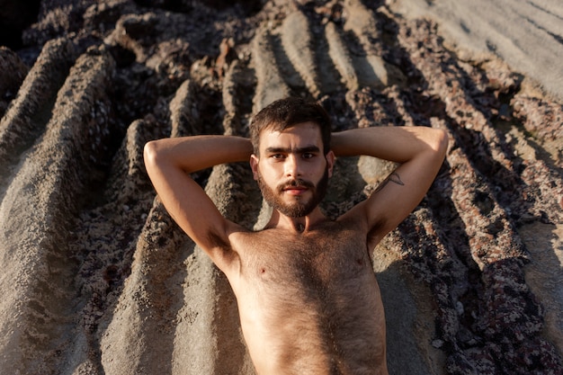 Gratis foto bovenaanzicht man met harige borst aan zee