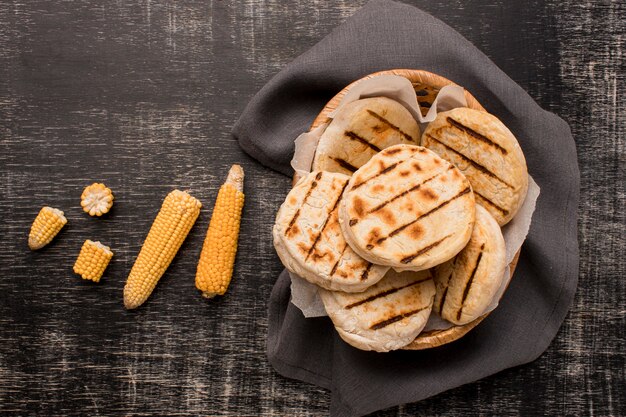 Bovenaanzicht mand met arepa's en maïs