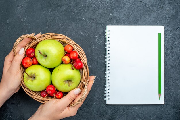 Bovenaanzicht mand met fruit appels en zoete kersen op donkergrijs oppervlak fruit bessen samenstelling versheid boom