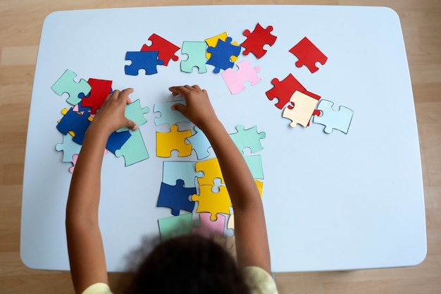 Bovenaanzicht meisje puzzel maken aan tafel