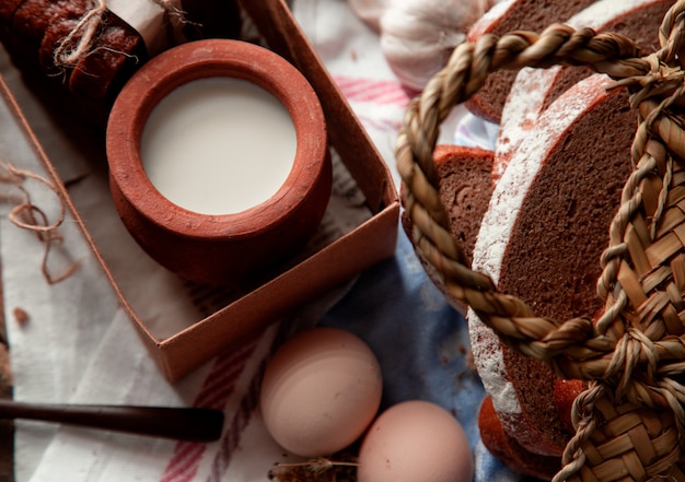 Gratis foto bovenaanzicht melk in een pot in doos, gesneden brood en eieren.