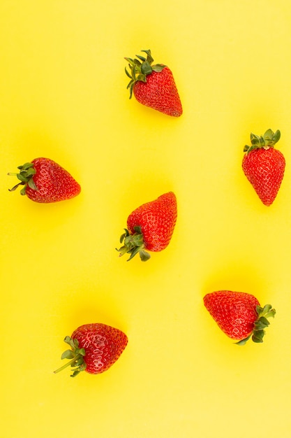 bovenaanzicht mellow sappige rode aardbeien geïsoleerd op de gele achtergrond
