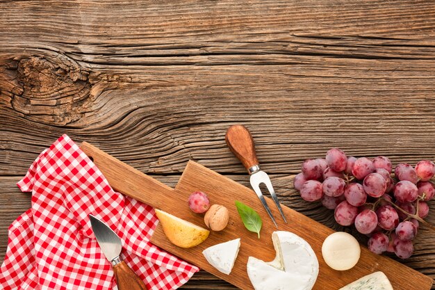 Bovenaanzicht mix van gastronomische kaas op houten snijplank met druiven
